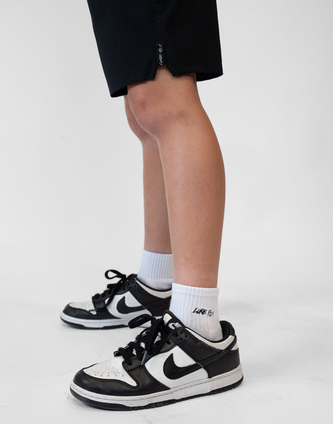 person wearing white socks with Luke 18:1 text in black