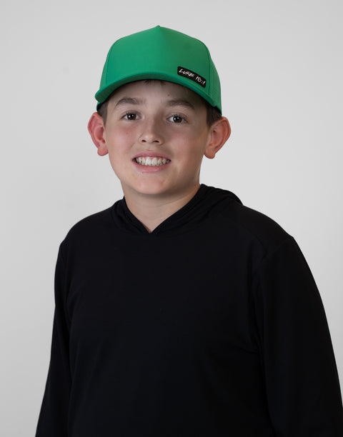 Child wearing kelly green hat with "LUKE 18:1" text