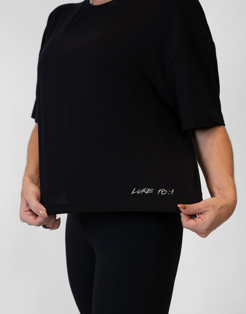 Woman wearing ladies Bamboo Mid-Crop Tee with "Luke 18:1" text above bottom seam
