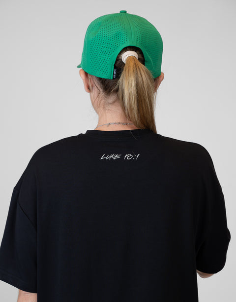Rear view of woman wearing ladies Bamboo Mid-Crop Tee with "Luke 18:1" text on upper back