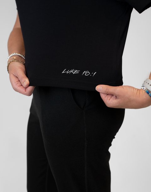 Woman wearing ladies Bamboo Mid-Crop Tee with "Luke 18:1" text above bottom seam