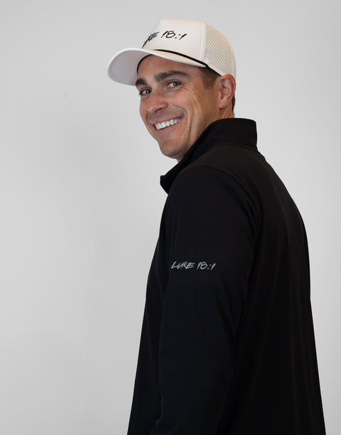 side view of Man wearing Men's black Performance 1/4-Zip with "LUKE 18:1" text on sleeve