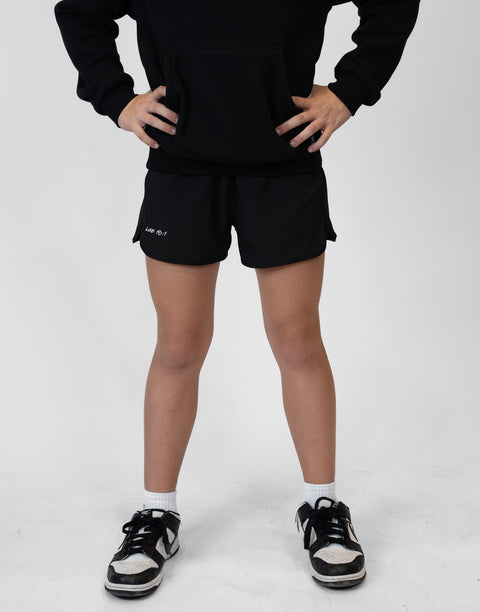 Girl wearing girls black flowy performance short with "LUKE 18:1" text