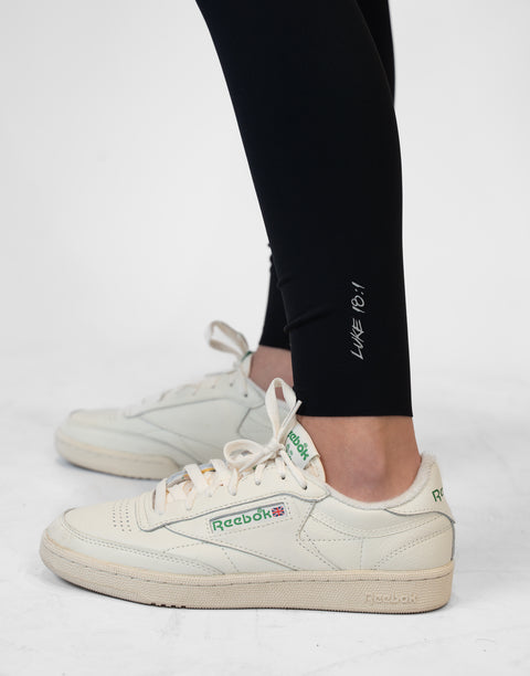 closeup of black Ladies Performance Legging with "LUKE 18:1" text on ankle