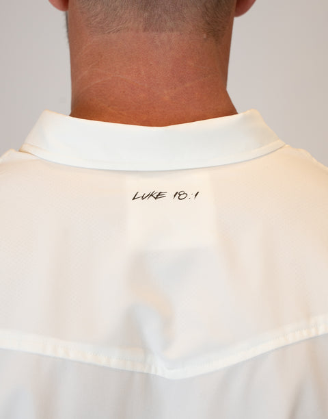 rear view of Man wearing Men's White S/S Pearl Snap Shirt showing "LUKE 18:1" text on upper back