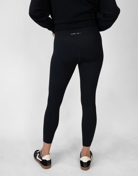 rear view of person wearing black Ladies Performance Legging with "LUKE 18:1" text on waistband