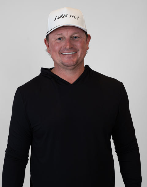 Person wearing white hat with black "LUKE 18:1" text