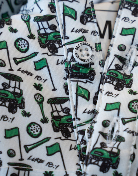 closeup of pattern of performance golf polo showing golf carts, flags, golf balls, tees, and "LUKE 18:1" text