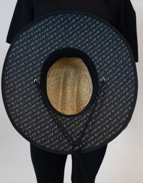 bottom view of straw hat showing "LUKE 18:1" text pattern under brim